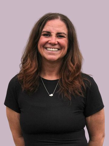 Smiling woman with wavy brown hair in a black shirt.