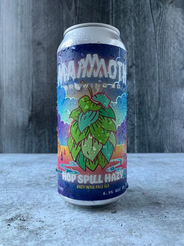 Hop Spill Hazy can with label depicting large hop surrounded by psychedelic landscape.
