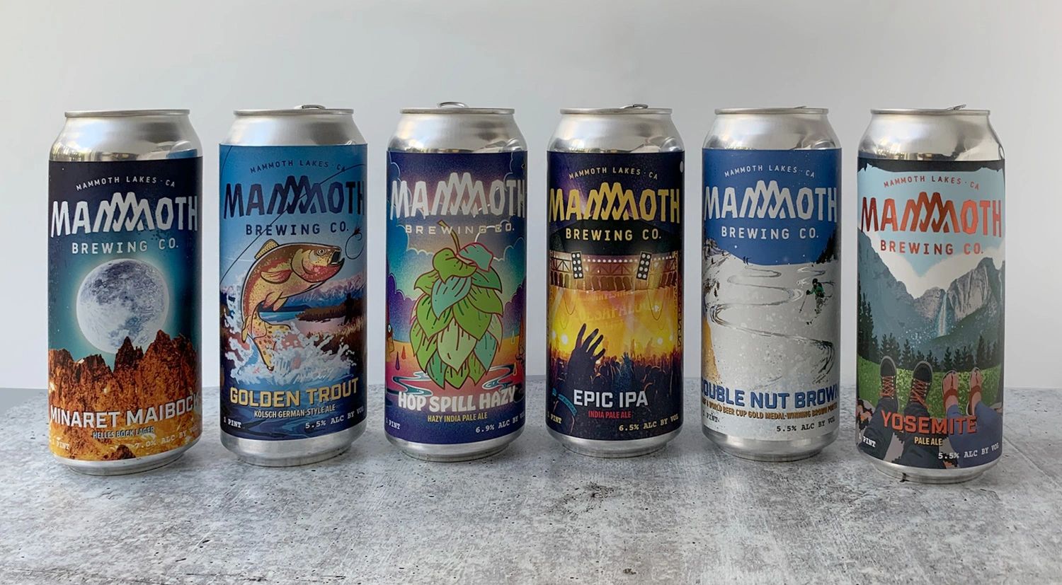 Six colorful Mammoth Brewing Company pint cans lined up next to each other.