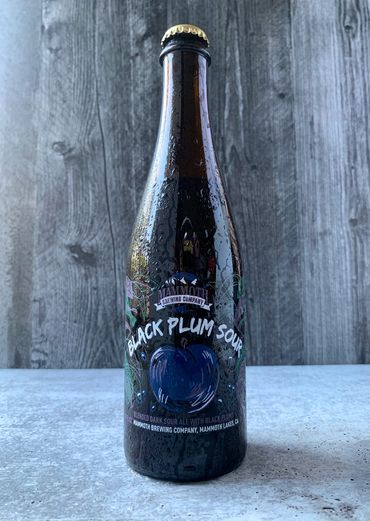 Black Plum Sour bottle depicting a loosely-drawn plum fruit and leaves. Typeface is brushy.