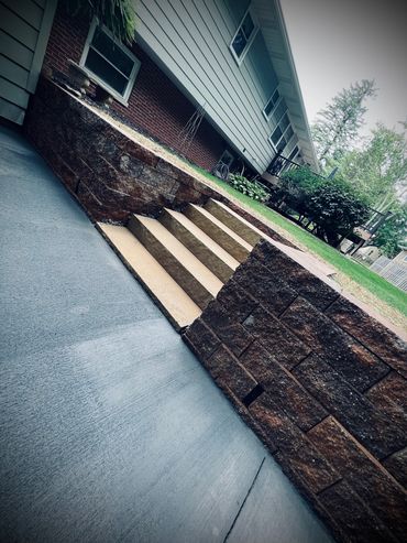 Poured concrete patio with retaining wall along with inset stair case to upper level of yard.