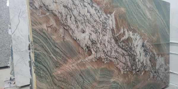 A large slab of polished marble with intricate green, brown, and white patterns.