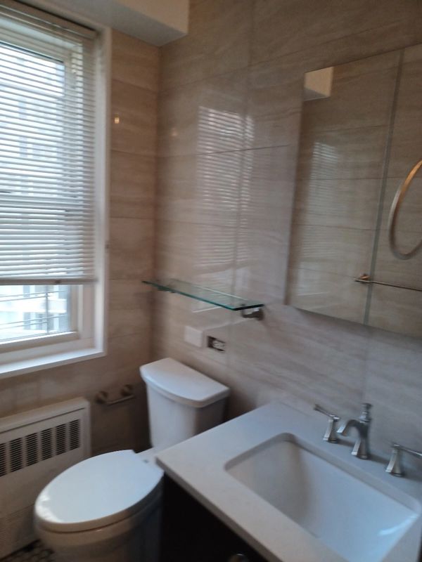 Small bathroom with a toilet, sink, and window with blinds.