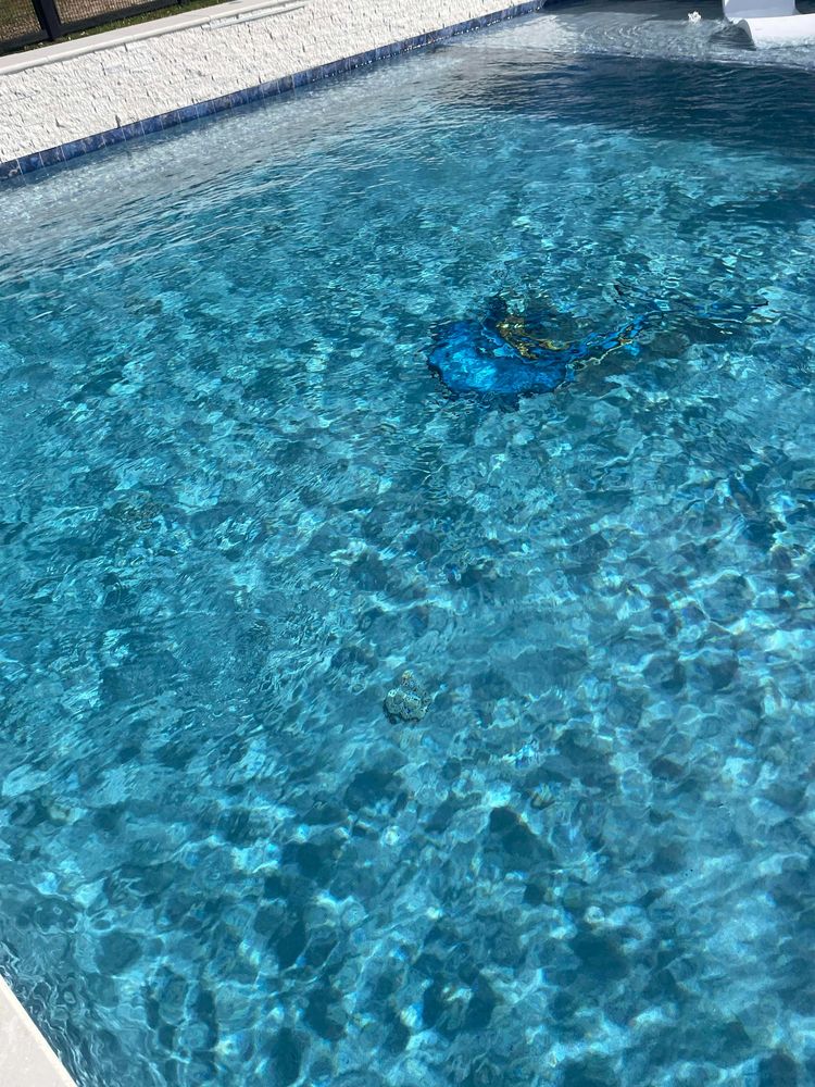Clear blue water in a swimming pool with sunlight reflections.