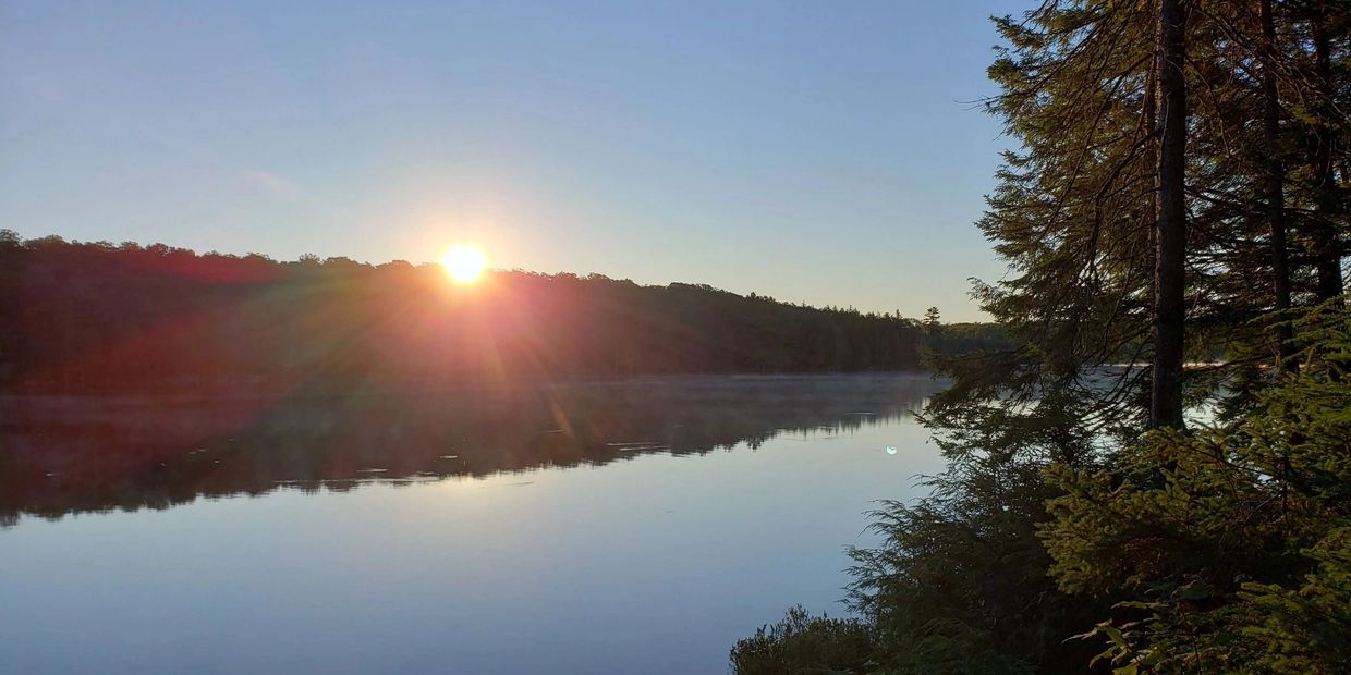 Sun rises over a lake in Ontario's Algonquin Provincial Park