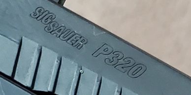 Close-up of a SIG Sauer P320 firearm.