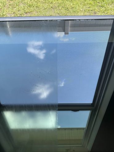 Half of a window is clean, the other half is fogged up with condensation.