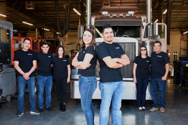 Group of seven people in a truck garage.