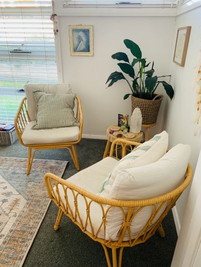 Cozy corner with rattan furniture and plants.