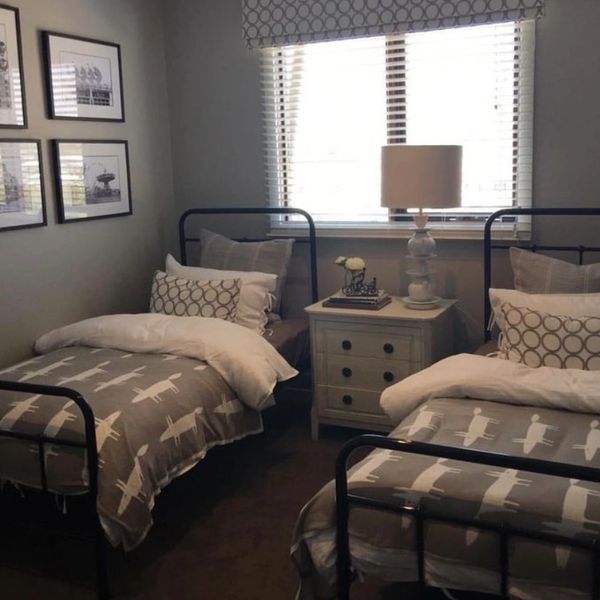 Cozy twin bedroom with airplane-themed bedding and neutral decor.