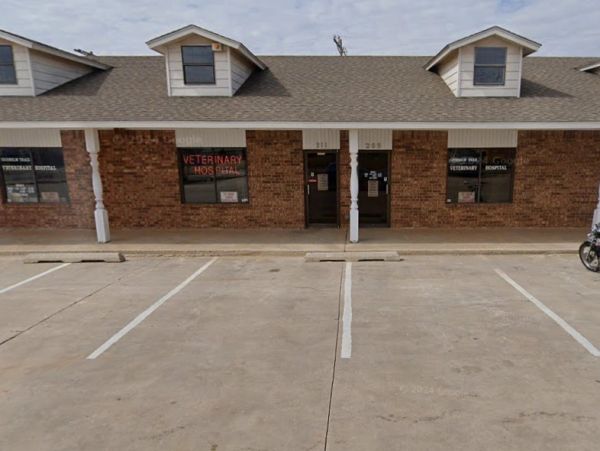 Exterior of a brick veterinary hospital with empty parking spaces.