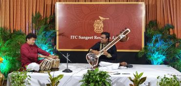 Two musicians performing with tabla and sitar at ITC Sangeet Research Academy.