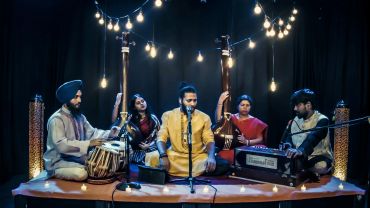 A group performing traditional Indian music with instruments and singing.