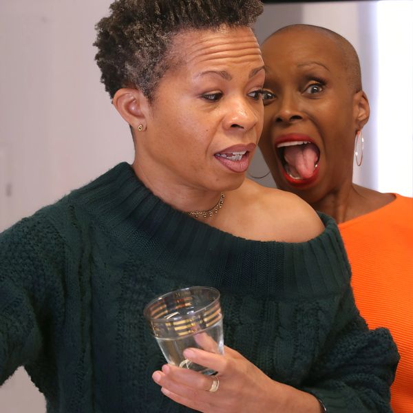 Two women with contrasting expressions, one surprised and one calm.