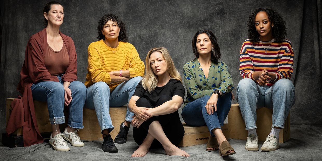 Five women sitting with serious expressions.