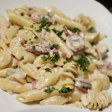 pasta with white sauce and sausage with herbs