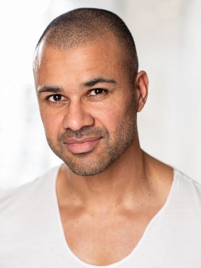 Confident man with a shaved head and light beard.