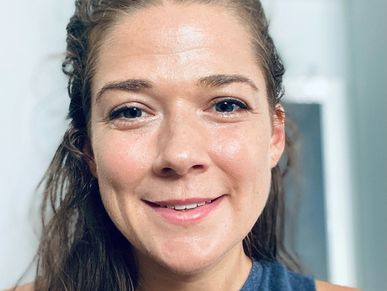 Front angle view of a lady with bright skin smiling at the camera