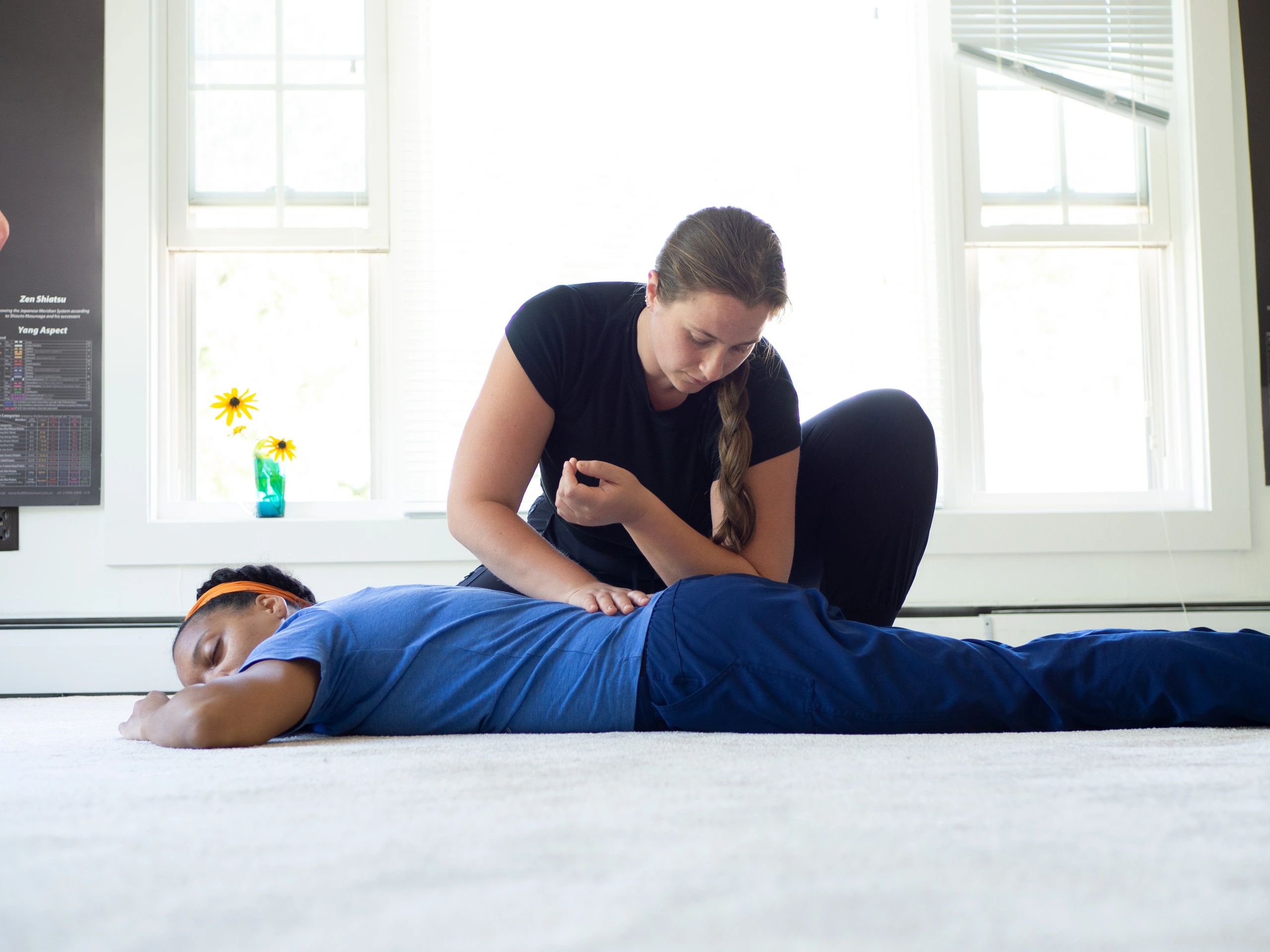 A lady pushing another lady hip with her hand