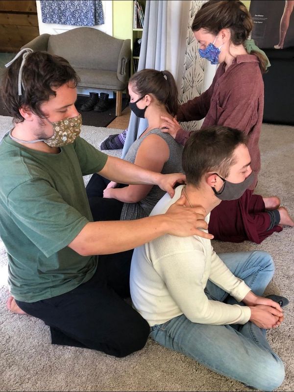 A man along with a girl massaging two people inside a room
