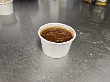 Savory house-made vegan brown gravy served at Bison Pizza Winnipeg. Perfect for poutine and dipping.