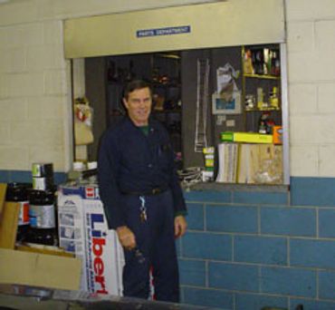 Staff member standing by the parts department window