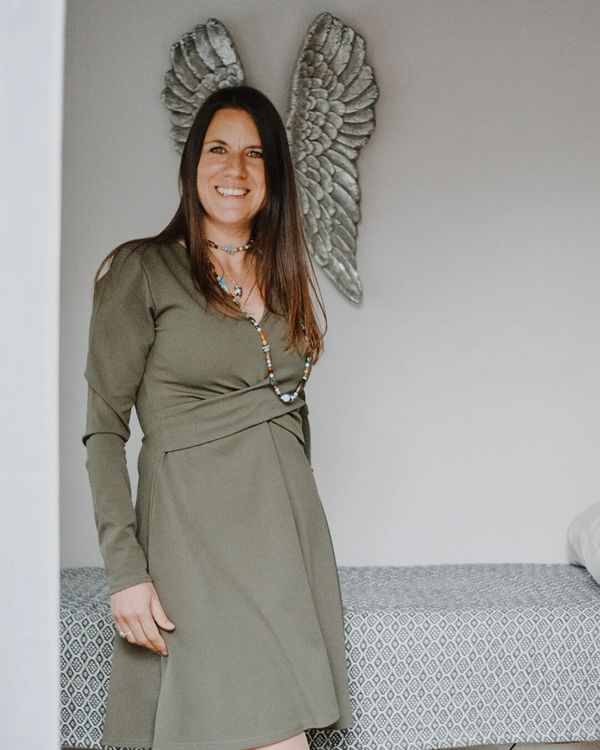 Rebecca Garratt in therapy room, standing in front of angel wings