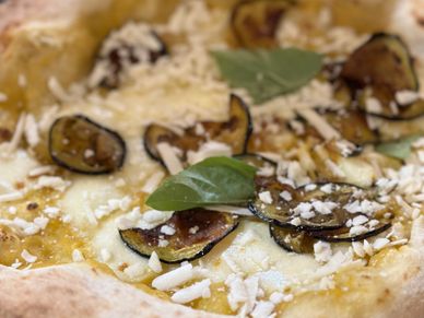 Pizza with yellow tomatoes, aubergines, pecorino cheese and basil
