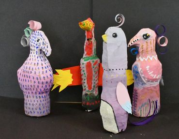 Four paper-mâché bird sculptures with colourful patterns and paper crests