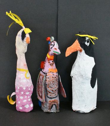 Three paper-mâché bird sculptures with colourful patterns and paper crests