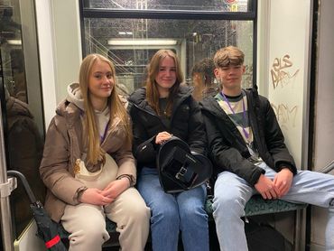 three students sitting on a bench