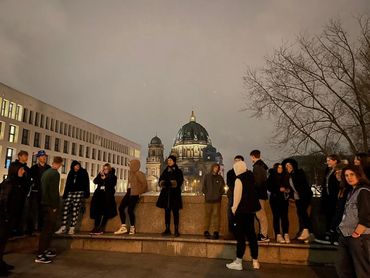 several students with a dome type building in the background
