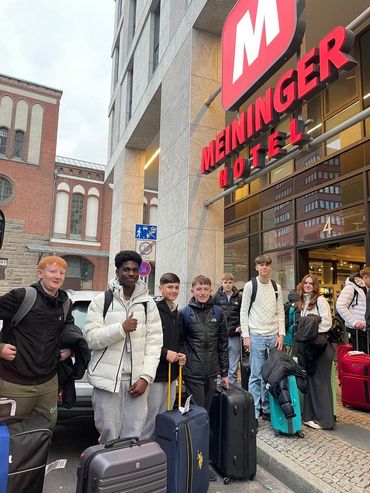 Group of students with luggage posing outside a hotel in Berlin