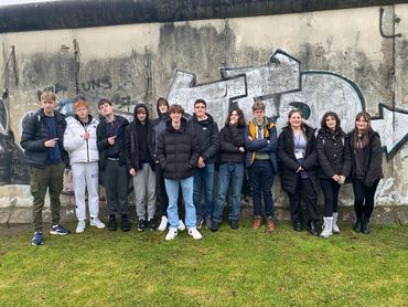Students posing in front of a graffitied section of the Berlin Wall (2 of 2)