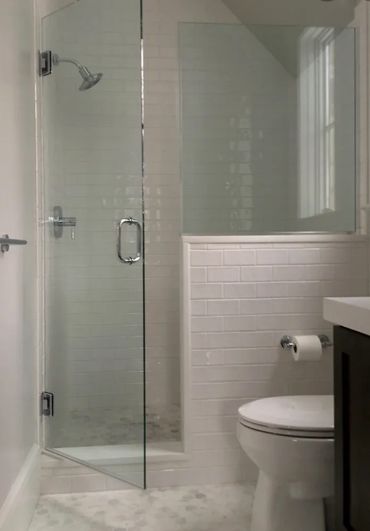 Modern bathroom with glass shower and white subway tiles.