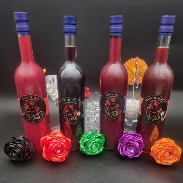 Four colorful juice bottles with matching decorative flowers on a black background.