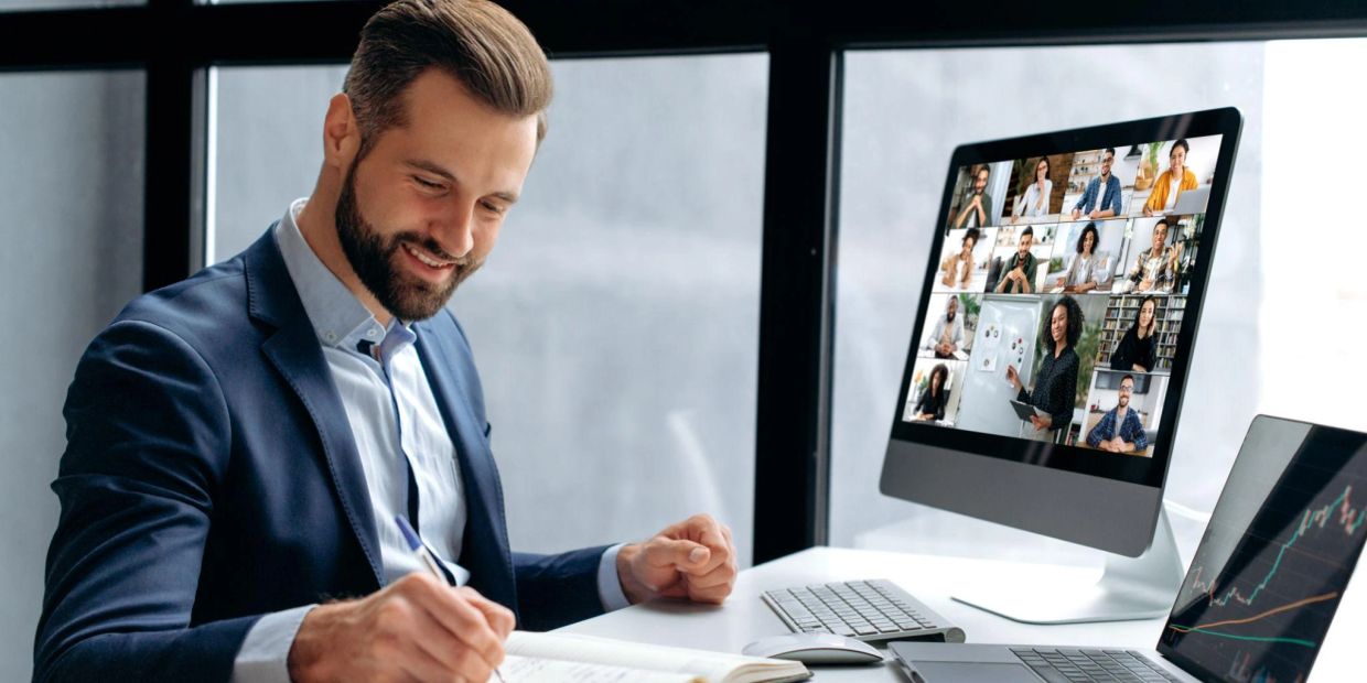 Man working while attending an online video meeting.