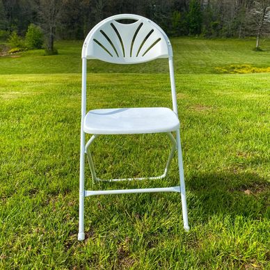 White folding chair on green grass.