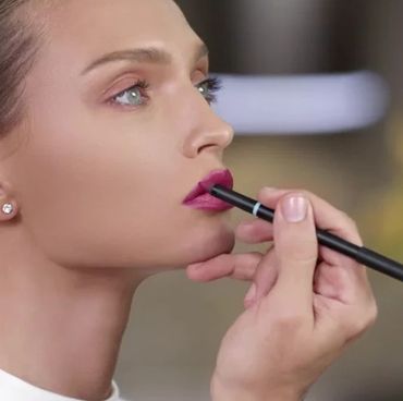 Woman putting lipstick on a man's face