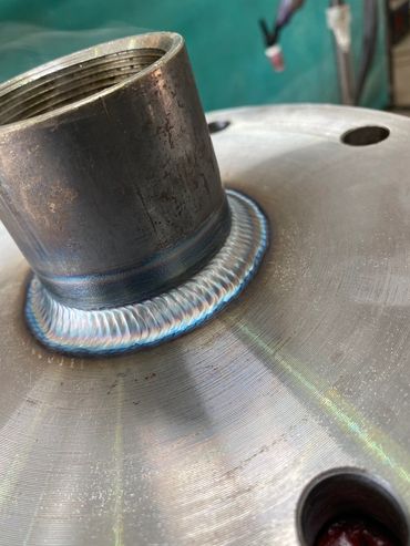 Close-up of a clean, precise metal weld on a cylindrical pipe joint.