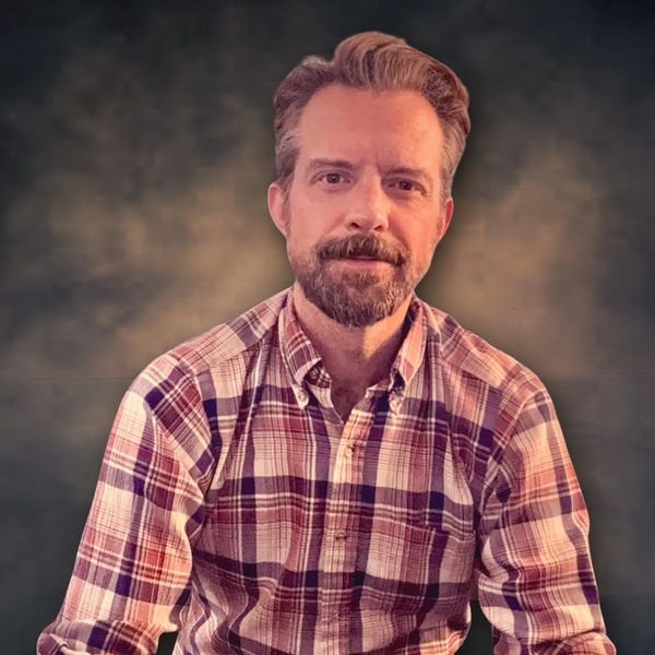 Man in a plaid shirt looking at the camera.