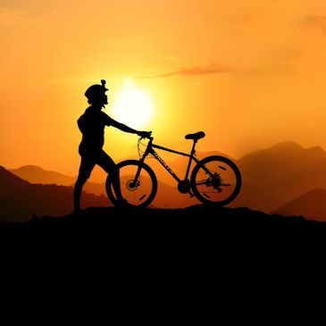 Silhouette of a cyclist with a mountain bike at sunset.