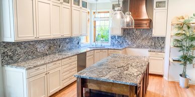 Bright kitchen with granite countertops and white cabinetry.