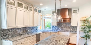 Bright kitchen with granite countertops and white cabinetry.