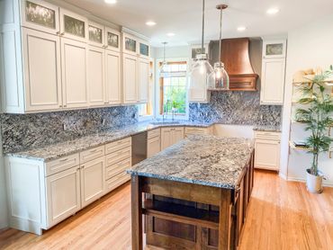 Bright kitchen with granite countertops and white cabinetry.