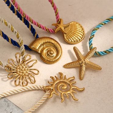 Golden sea-themed pendants on colorful twisted cords.
