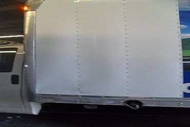 A Truck Side View With a White Metallic Section