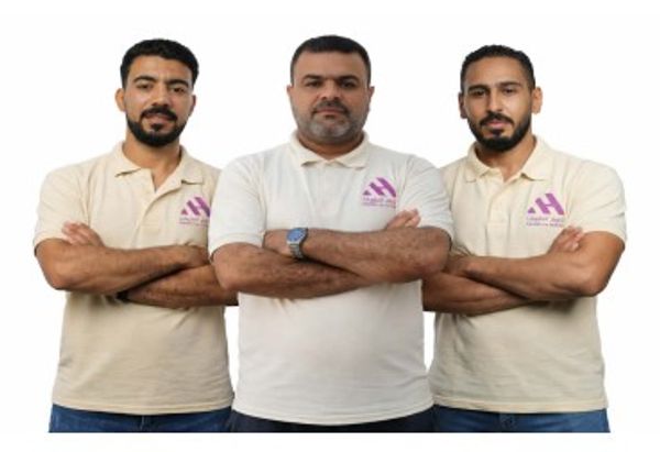 Three men standing with arms crossed, wearing matching polo shirts.