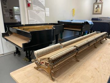 A grand piano action stack removed from inside the piano. The empty piano cavity. 