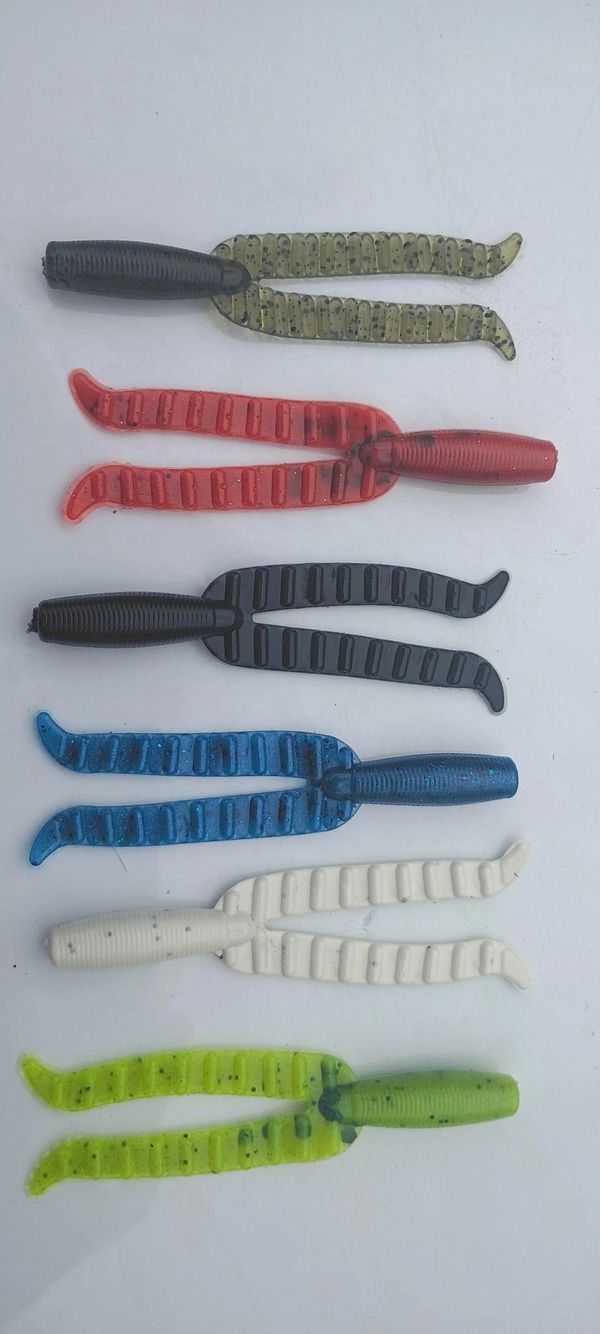 Colorful soft plastic fishing lures with twin tails arranged vertically.